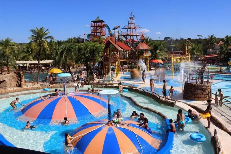 Parque aquático em SP, atrações coloridas com muitas pessoas se divertindo em meio a água cristalina.