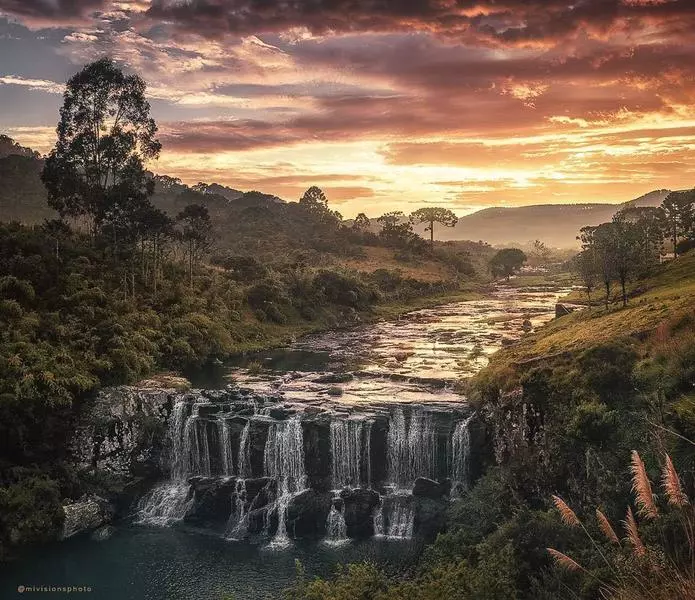 Serra do rio rastro, uma cascata  curta de fluxo pedregoso cercada por natureza a sob um céu durante um pôr do sol magnífico.