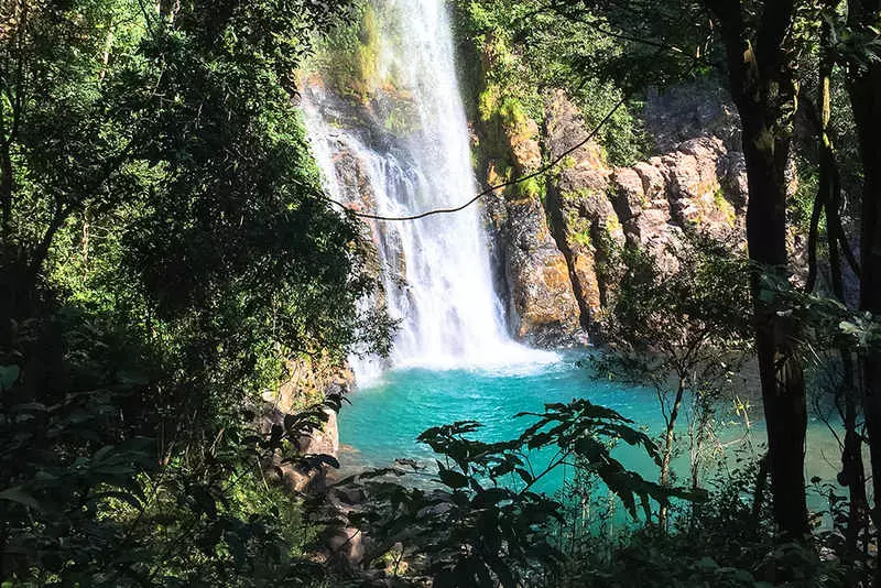 Cachoeira da Serra Azul, de água azul cristalina, cercada de vegetação local em Nobres MT